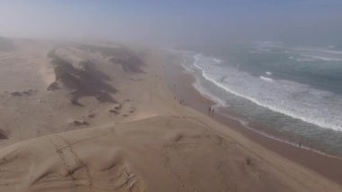 İHA arka planda sis dalgalarıyla kıyı şeridi boyunca uçuyor