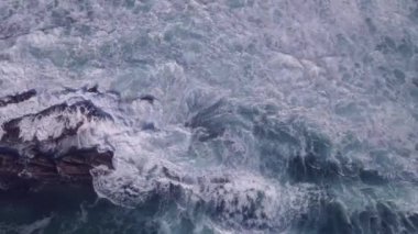 İnsansız hava aracı okyanustaki dalgaların üzerinde uçuyor.