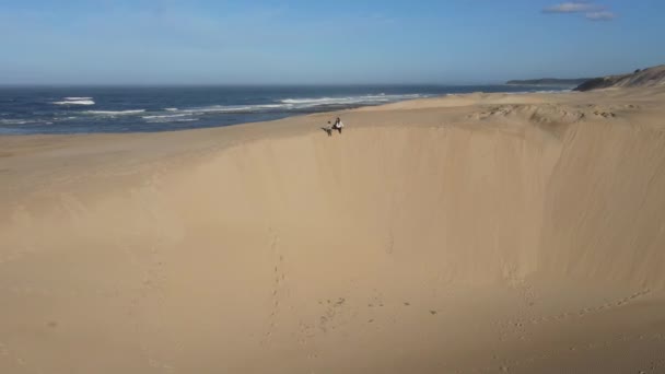 Mujer y su hijo sentados en el borde de la duna — Vídeos de Stock