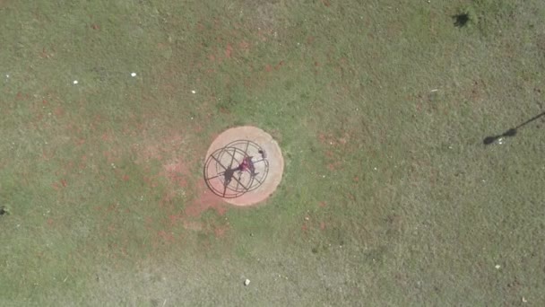 Drone descendo em direção roda de fiação no parque — Vídeo de Stock
