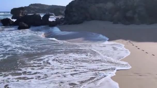 Drone flying low across shoreline passing rocky enclave — Stock Video