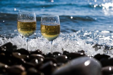 İki bardak beyaz şarap ya da deniz köpüğüne karşı buzlu şampanya standı. Kutlama ya da romantik randevu konsepti