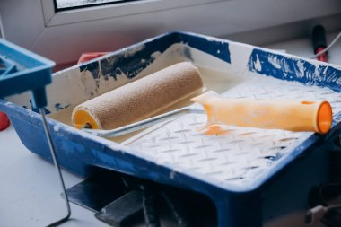 Beyaz boyalı silindir banyoda. Duvar kağıdı ve duvarları onarma ve yeniden boyama kavramı