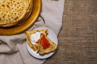 Gri peçetede kırmızı havyarlı ince gözlemeler. Rus karnavalı Maslenitsa konsepti. Metin için boşluk