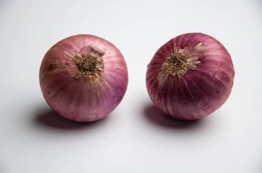 Beyaz bir zemin üzerinde kırmızı soğanlar 