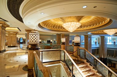 Abu Dabi, BAE 'deki Emirates Palace otelinin varlıklı lobisinde mermer, altın yaprak ve büyük avizeler sergilenmekte ve lüks tasarımı sergilenmektedir..