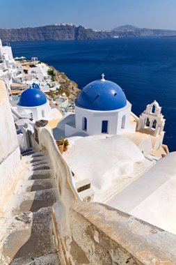 Santorini, Yunanistan: Beyazlatılmış binalar ve mavi kubbeli kiliseler Oia kayalıklarına yapışarak Ege Denizi ve kalderanın nefes kesici manzaralarını sunuyorlar.