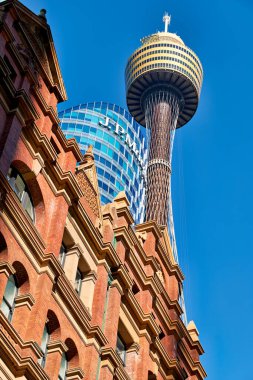 Sydney Tower Eye, Avustralya 'nın en yüksek yapısı, arkasında J.P. Morgan binası olan tarihi tuğla bir binanın arkasında duruyor..