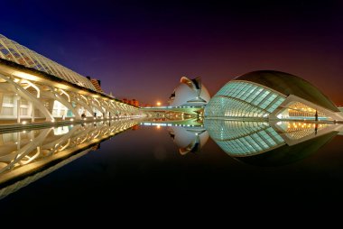 Hemisferic gece boyunca Valencia Sanat ve Bilim Şehri 'nde dimdik ayakta duruyor. Yansımalar suda parıldıyor.
