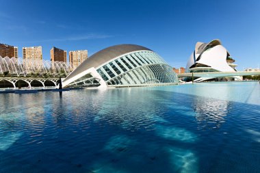 Ziyaretçiler Valencia İspanya 'daki Hemisferic yapısını güneş ışığının suya yansıması olarak görüyorlar. Gün aydınlık ve berrak, canlı bir atmosfer yaratıyor..