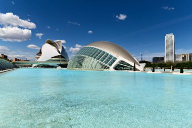 Ziyaretçiler Valencia 'daki Sanat ve Bilim Şehri' ni keşfediyorlar. Hemisferic 'ler mavi gökyüzüne karşı dimdik duruyorlar..