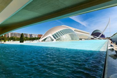 Sanat ve Bilim Şehri 'nde su temiz. Hemisferic binası mavi gökyüzüne karşı duruyor ve su yüzeyine yansıyor..