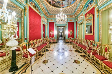 İnsanlar Valencia 'daki Ulusal Seramik ve Dekoratif Sanatlar Müzesini keşfediyorlar. Ziyaretçileri çevreleyen parlak kırmızı duvarlar ve ayrıntılı tasarımlar.