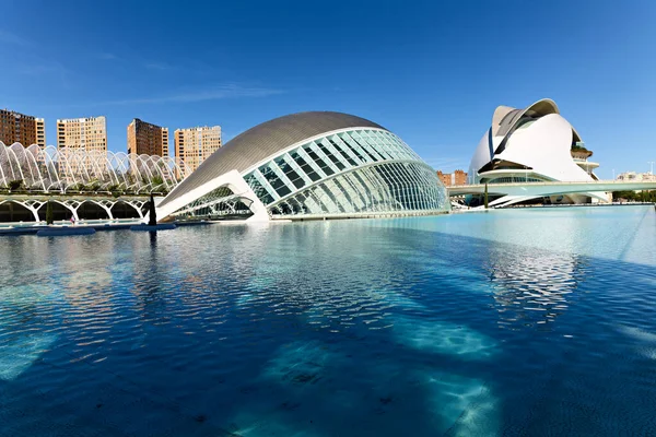 Ziyaretçiler Valencia İspanya 'daki Hemisferic yapısını güneş ışığının suya yansıması olarak görüyorlar. Gün aydınlık ve berrak, canlı bir atmosfer yaratıyor..