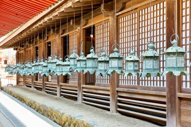 Nara Japonya 'da ahşap bir yapı boyunca dua fenerleri asılıdır. Sahnede ayrıntılı tasarımlar ve geleneksel işçilik yer alıyor..