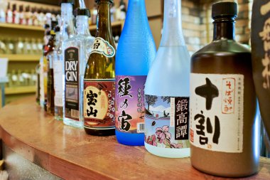 Kyoto 'da bir tezgahta çeşitli sake şişeleri düzenlenir. Her şişe farklı tasarım ve etiketleri gösteriyor..