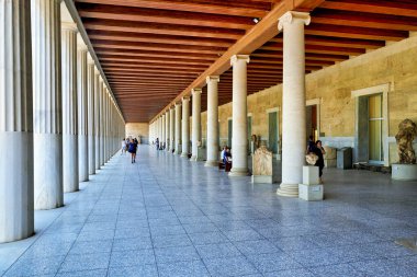 Atina 'da insanlar Attalos Stoa' sından geçiyor. Yapıda uzun sütunlar ve antik eserler sergileniyor..