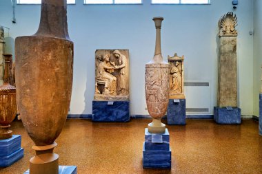 Ziyaretçiler, yoğun bir öğleden sonra Yunanistan 'ın Atina kentindeki Ulusal Arkeoloji Müzesi' nde antik heykel ve vazolara bakıyorlar.