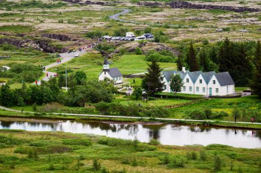 İnsanlar İzlanda 'daki Thingvellir' de yürüyor, tarihi bir yer. Doğa çevreyi sarmış..