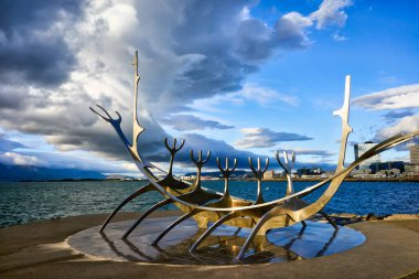 Güneş Voyager heykeli Reykjavik 'te suyun kenarında duruyor. Bu heykel bulutlu gökyüzünün altında ufka doğru bakıyor. Birçok insan burayı ziyaret eder..