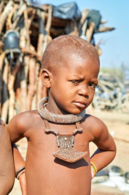 Namibya 'nın Kunene bölgesindeki Himba köyündeki çocuklar geleneksel giysi ve aksesuarlarla günlük yaşamla ve kültürel uygulamalarla ilgileniyorlar..