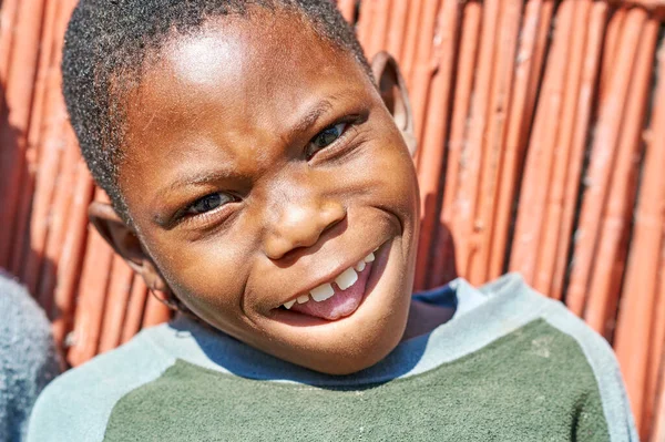 Kavango Bölgesi 'nde parlak gülüşlü bir çocuk duruyor. Bu, Namibya 'da yakalanan bir sevinç anı..