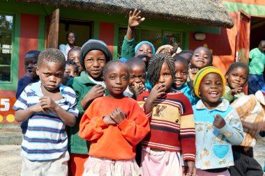Çocuklar, Kavango Bölgesi, Rundu 'da bir okulun sınıfında toplanıyorlar. Gülümser ve etkileşirler, canlı bir atmosfer yaratırlar..