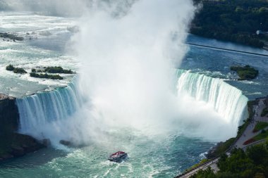 Hornblower teknesindeki turistler, Kanada 'nın Niagara Şelalesi' ndeki Horseshoe Şelalesi 'ndeki sise karşı güçlü şelalenin unutulmaz yakın çekim görüntüsü için cesurca göğüs gerdiler..