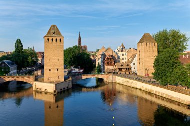 Gün batımında Strasbourg 'da deniz kenarında köprüler ve kuleler bulunur. Binalar Alsace 'ın bu bölgedeki geçmişini gösteriyor..