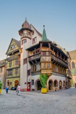 Ziyaretçiler, Alsace, Colmar 'daki tarihi Maison Pfister' ı mavi gökyüzünün altında keşfediyorlar. Eşsiz mimari birçok insanı cezbediyor..