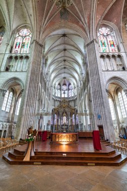 Auxerre Katedrali 'nin içinde yüksek tavanlar ve renkli vitraylar var. Sunak ahşap oturma düzeniyle görülebilir..