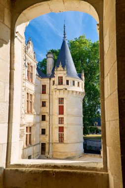 Ziyaretçiler Loire Valley 'deki bir pencereden Azay d' Azay le Rideau Şatosu 'na bakıyorlar. Bu bina tarihi ve mimariyi gösteriyor..
