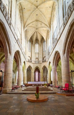 İnsanlar güneşli bir günde Dinan, Brittany 'deki Eglise Saint Malo' nun içini keşfediyorlar. Yüksek tavanlar etkileyici bir atmosfer yaratır..