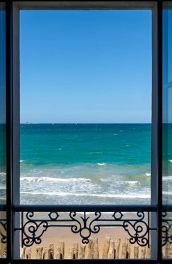 İnsanlar Grand Plage du Sillon 'da güneş ve denizin keyfini çıkarıyor. Saint Malo' da parlak bir gökyüzünün altında okyanus dalgaları akıyor..
