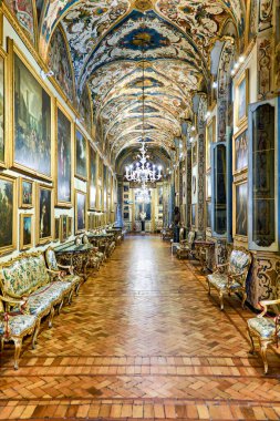 Ziyaretçiler Roma 'daki Doria Pamphilj Galerisini keşfediyor, süslü bir tavanın altındaki sanat eserlerine ve güzel dekorlara bakıyorlar..