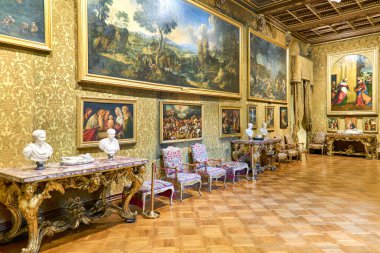 Doria Pamphilj Galerisi büyük bir odada çeşitli sanat eserleri ve heykeller sergiliyor. Duvarlar resimler ve dekoratif çerçevelerle dolu..