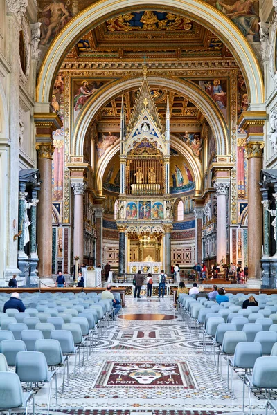 Roma 'daki Archbazilica Katedrali' nden insanlar geçiyor. Mekan güzel mimari ve dini sanat eserlerini gösteriyor..