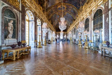 Turistler Versailles Sarayı 'ndaki Büyük Galeri' de yürürler. Bu ünlü tarihi yerdeki sanat ve mimariye hayranlar..