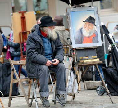 Bir sanatçı Paris 'te bir sokak pazarında otururken onun resmedilmiş portresini gözlemler. İnsanlar canlı atmosferin tadını çıkararak yürüyorlar..