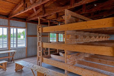 Bu, Münih 'teki Dachau toplama kampındaki yatakhaneyi gösteriyor. Basit ahşap yapılar pencereleri açık olan satırlara yerleştirilir.