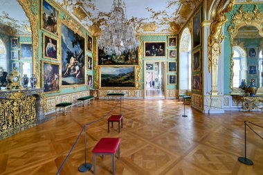 Ziyaretçiler Almanya 'nın Münih kentindeki Residenz Sarayı' nın büyük iç kısımlarını keşfediyorlar. Odada ayrıntılı dekorasyon, tablolar ve zarif mobilyalar yer alıyor..