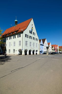 Schongau 'nun belediye binası gün ışığında duruyor. Caddeye yakın binalar. Sahne, üzerinde mavi gökyüzü olan sessiz bir bölgeyi gösteriyor..