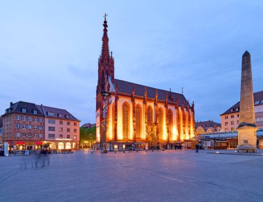 Ziyaretçiler Wurzburg 'daki Marienkapelle' de yürürken kilise alacakaranlıkta aydınlanıyor. Dekor büyüleyici bir atmosfer ve tarihi mimariyi gözler önüne seriyor..