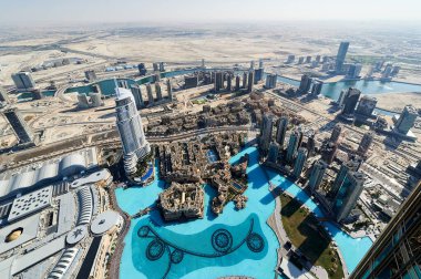 Dubai üzerinde suni göl ve çöl manzaralı yüksek binalar süzülür. Şehirdeki yollar çeşitli yapıları birbirine bağlıyor..