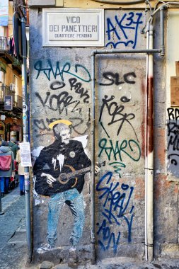 Sokak grafitisi Pino Daniele 'nin Napoli' de bir duvarda gitar çaldığını gösteriyor. Sanat eserleri çeşitli etiket ve graffiti stilleriyle çevrilidir..