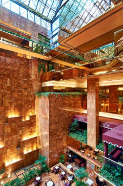 Ziyaretçiler Manhattan 'daki Trump Tower Atrium' u keşfediyor. Yoğun bir öğleden sonra boyunca modern tasarım ve geniş planların tadını çıkarıyorlar..