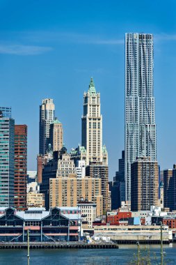 New York 'ta açık bir günde çeşitli bina ve yapıları gösteren Manhattan silueti görüntüsü. Bu sahne şehir yaşamını ve mimarisini yakalıyor..
