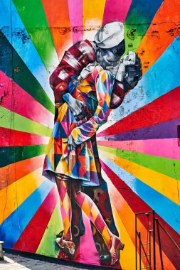 Manhattan 'daki High Line' da renkli bir duvar resminde bir çift öpüşüyor. Sanat eserleri bölgeyi aydınlatıyor ve pek çok ziyaretçi çekiyor..