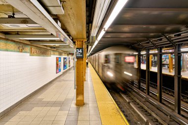 Manhattan 'daki 34. Cadde istasyonuna bir metro treni yaklaşıyor. Tren geldiğinde insanlar platformda bekliyor..