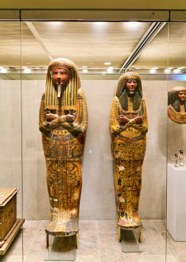 Ziyaretçiler Manhattan 'daki Metropolitan Sanat Müzesi' ndeki antik Mısır eserlerine bakıyorlar. Ekranda ayrıntılı lahit yer alıyor..